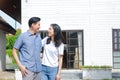 Asian male and female couples stand, hug, and smile happily in front of the new house. Royalty Free Stock Photo