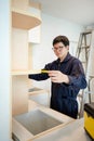 Asian male furniture assembler using tape measure Royalty Free Stock Photo