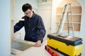 Asian male furniture assembler using tape measure Royalty Free Stock Photo