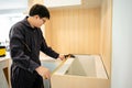 Asian male furniture assembler using tape measure Royalty Free Stock Photo