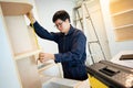 Asian male furniture assembler using tape measure Royalty Free Stock Photo