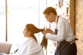 Asian male hairdresser make hairstyles for Asian female customers in modern beauty salons.