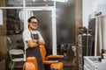 asian male hairstylist standing confidently in barbershop with folded hand Royalty Free Stock Photo
