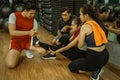 asian male instructor straightens leg of woman having muscle cramps