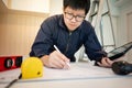 Asian male Interior worker working with architectural drawing Royalty Free Stock Photo