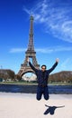 An Asian male jumping in front of Eiffel Tower