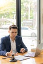 Asian male lawyer working on legal contract documents and hammer and scale with laptop placed in front in the courtroom. justice a Royalty Free Stock Photo