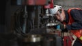 Asian male machanic engineer supervisor checking and tuning drilling machine in metwork and part manufacturing factory Royalty Free Stock Photo