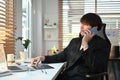 Asian male marketing sales manager consulting client, talking on mobile phone and using laptop pat working desk Royalty Free Stock Photo