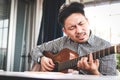 Asian male musician playing guitar in recording studio. Royalty Free Stock Photo