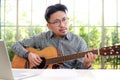 Asian male musician playing guitar in recording studio. Royalty Free Stock Photo