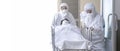 Asian male nurse and doctor wearing ppe suit and face mask pushing stretcher gurney bed with seriously infected coronavirus or Royalty Free Stock Photo