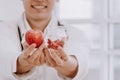 Asian male nutritionists hold red apples