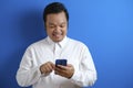 Asian male office worker accessing his smart phone with confidence feeling