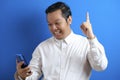 Asian male office worker looks confident while accessing his smart phone