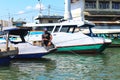 Asian male parking his boat over the sea, fisherman resting his wooden boat at the port or harbor area