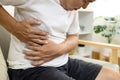 Asian male patient with abdominal pain on right side belly,painful in abdomen,irritable bowel,middle-aged man holds under the ribs Royalty Free Stock Photo