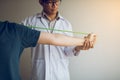 Asian male physical therapist descent working and helping to protect the hands of patients with patient doing stretching exercise Royalty Free Stock Photo