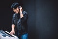 Asian male playing an electric keyboard while wearing headphones in the recording studio. Recording songs by using a studio Royalty Free Stock Photo