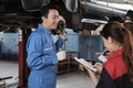 Supervisor engineer is teaching mechanic workers about car repair at a garage. Royalty Free Stock Photo