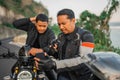 asian male riders sitting motorbike conversating Royalty Free Stock Photo