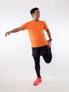 Asian male runner warming up prepararing his body before running workout. stretch his leg muscle, studio full length portrait Royalty Free Stock Photo