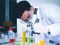 Asian male scientist Is working seriously Chemistry experiment With a microscope In the laboratory Royalty Free Stock Photo