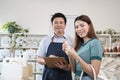 Portrait of an Asian male shopkeeper and a female customer in a refill store