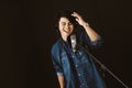 Asian male singer recording songs by using a studio microphone and pop shield on mic with passion in a music recording studio. Royalty Free Stock Photo