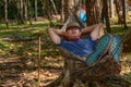Asian male sleeping in hammock in camping in forest