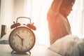 Asian male stretching out after woke up with alarm clock showing six o clock Royalty Free Stock Photo