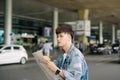 Asian male tourist reading map while waiting for taxi at the air Royalty Free Stock Photo