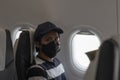 Asian male tourist wear medical face mask sitting in an airplane to protect to coronavirus