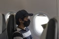 Asian male tourist wear medical face mask sitting in an airplane to protect to coronavirus