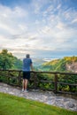 Asian male tourists looking at the mountain view and fog in the morning at canyon Nam Nao in Phetchabun Province, unseen Thailand