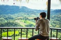 Asian male tourists take pictures of mountain landscapes after rain in northern Thailand.