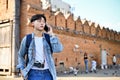 Asian male traveler talking on the phone, calling someone while standing at Tha-Phae gate