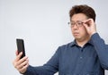 Asian male trying to read something on his mobile phone. poor sight, presbyopia, myopia