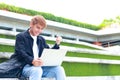 Asian male university student using laptop to study Smiling with arms raised Royalty Free Stock Photo