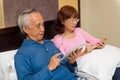 Asian male using tablet in bed Royalty Free Stock Photo