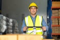 Asian Male warehouse worker pulling a pallet truck. middle aged Asian warehouse worker preparing a shipment in large warehouse Royalty Free Stock Photo