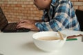 Asian male worker hastily eats instant noodles at busy overtime work Royalty Free Stock Photo