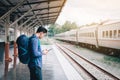 Asian man backpack for travel at train station and using tablet searching map location Royalty Free Stock Photo