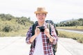 Asian man with backpack using camera while traveling in summer time Royalty Free Stock Photo