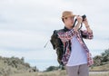 Asian man with backpack using camera while traveling in summer time Royalty Free Stock Photo