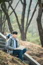 Asian man backpacking using laptop. Royalty Free Stock Photo