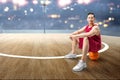 Asian man basketball player sitting on the ball Royalty Free Stock Photo