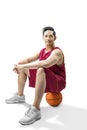 Asian man basketball player sitting on the ball Royalty Free Stock Photo