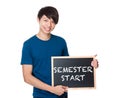 Asian man with the blackboard showing phrase of semester start