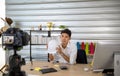 Asian man blogger broadcasting a video for selling product online such as Hats, shoes, headphones, clothing, safety headers. Royalty Free Stock Photo